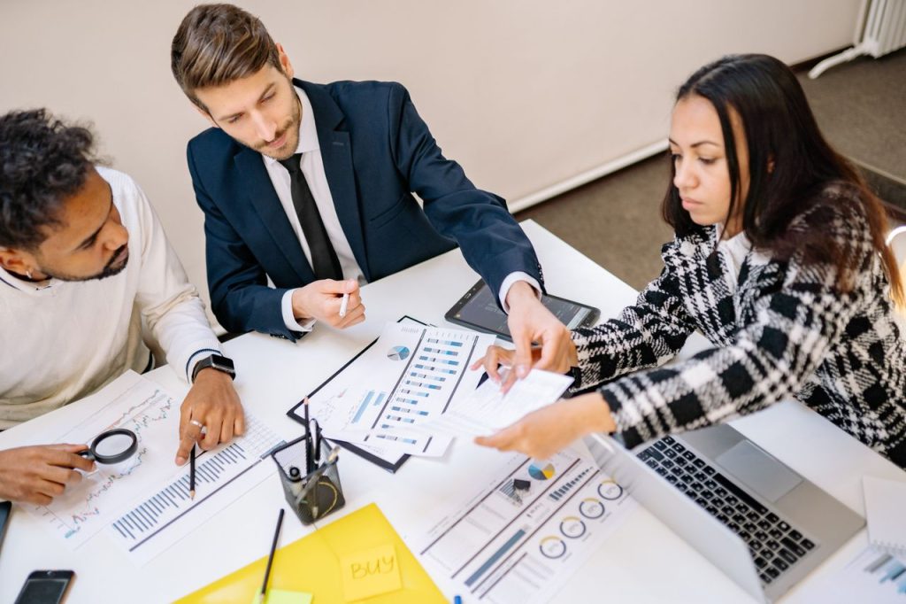 The Art of Drawing Readers In: Your attractive post title goes here Business professionals engaging in a collaborative meeting with charts and documents.